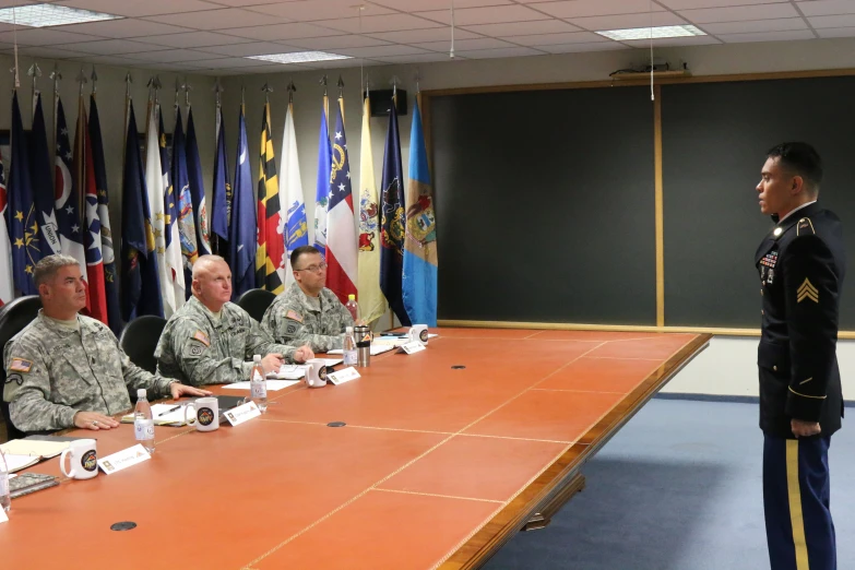 several military men sitting at a table during the day