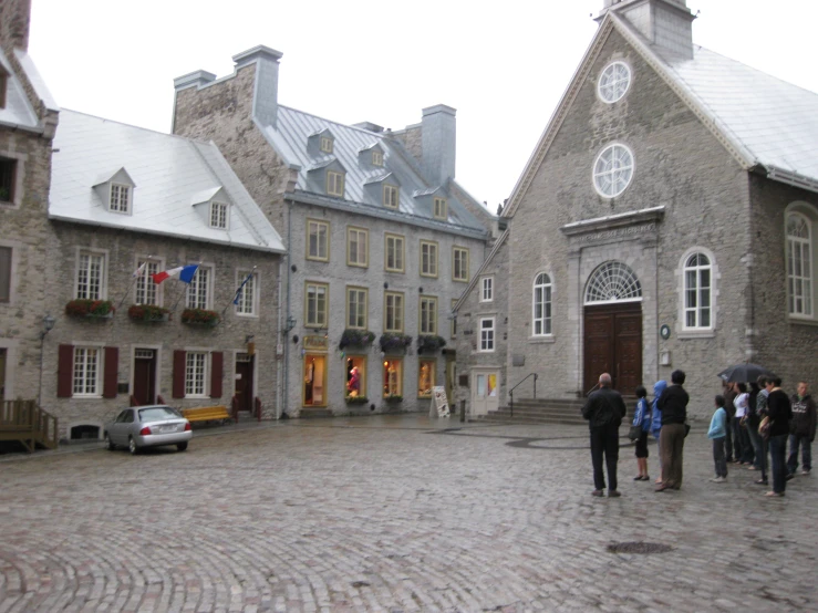 many people walking and sitting around outside an old brick building