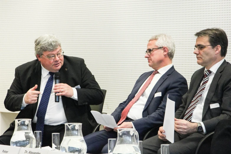 three men are sitting at a round table