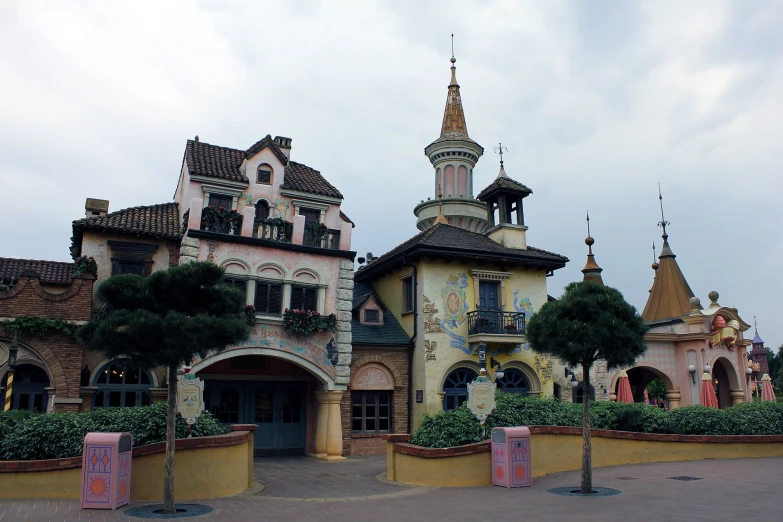 there are several buildings on a road that has many windows and a clock on it