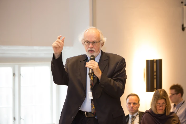 a man holding a microphone in front of a crowd