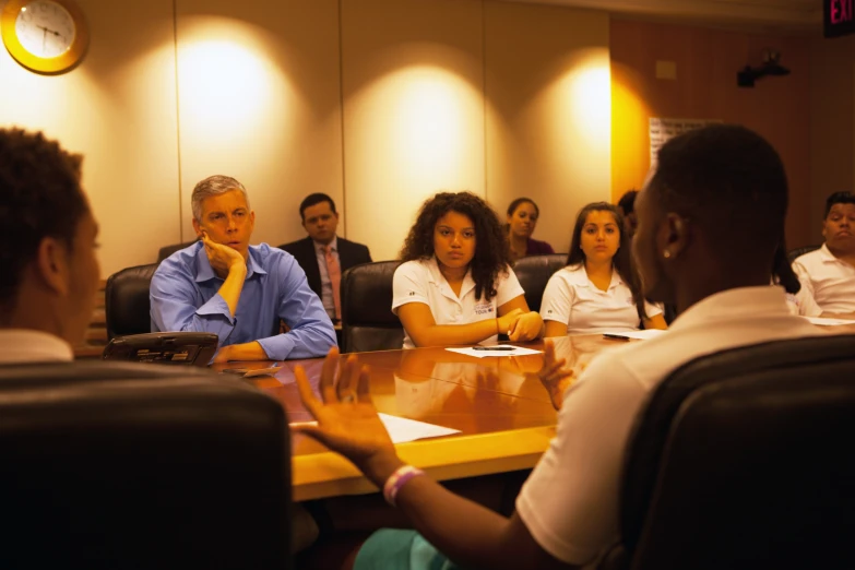 people sitting at desks in a meeting room