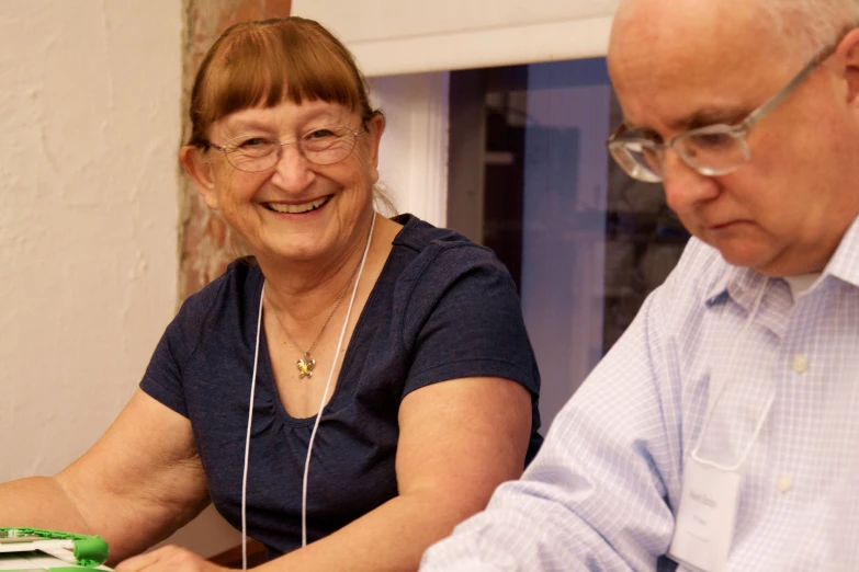 a man and a woman smiling with their laptops