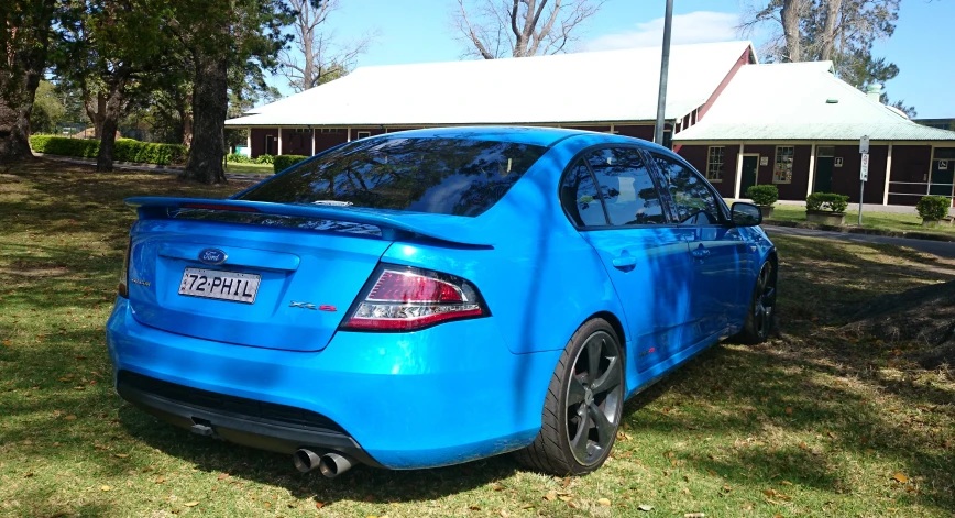 a car that is blue parked in the grass