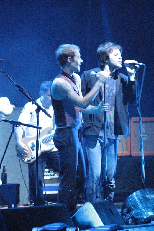 two male musician with the guitar playing on stage