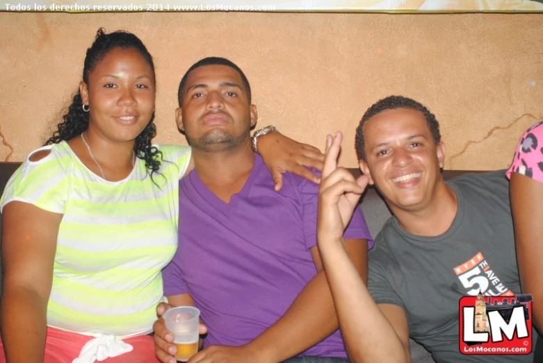 three friends posing together for a picture with an image behind them