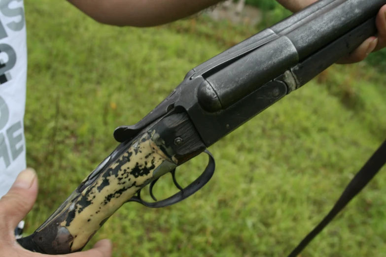 a hand holding a small gun with paint splatters