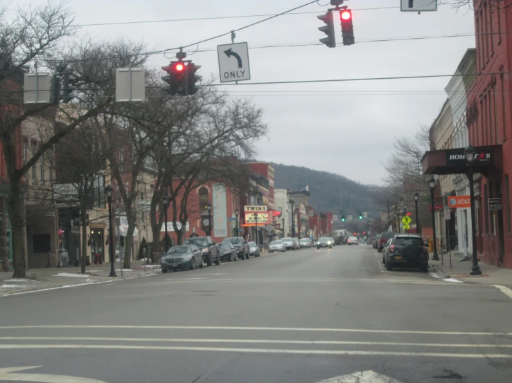 an empty city street with stoplights and parked cars