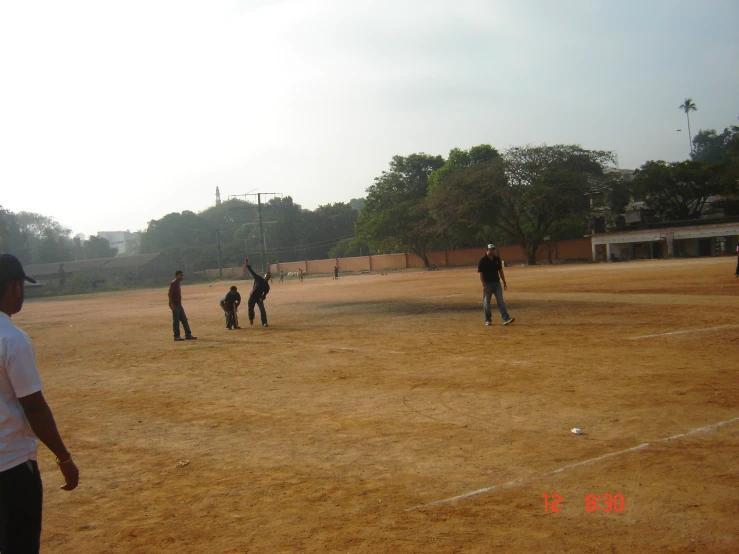 people are playing baseball in an empty field