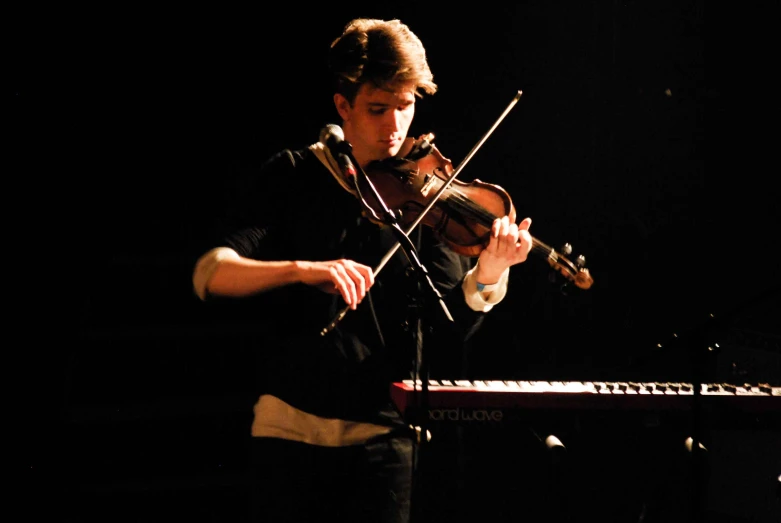 a man in black shirt playing a violin