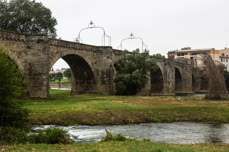 an old stone bridge with the city in background