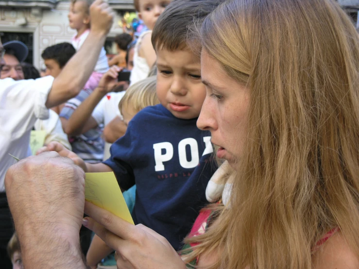 a woman and a child sitting on the side of a boat with their handwritten notes