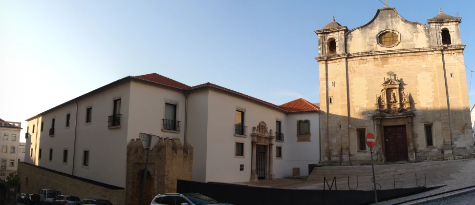 a church with two towers and cars parked in front