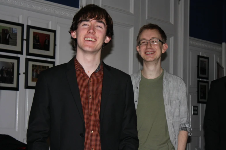 two men smiling together in the middle of the room