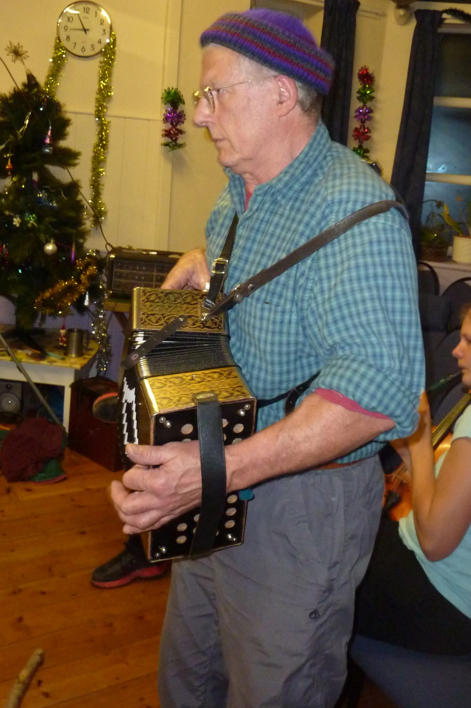 an elderly man playing a small black and gold piece of art