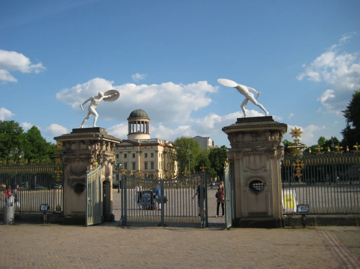 two statues with an ornate building in the background