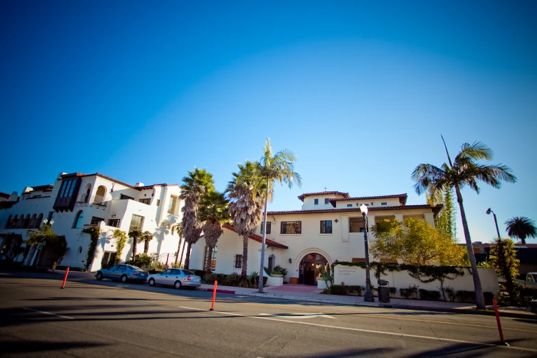 there is a tall building with many windows and palm trees