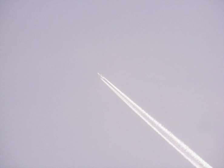 a jet flying in the sky leaving a trail of smoke