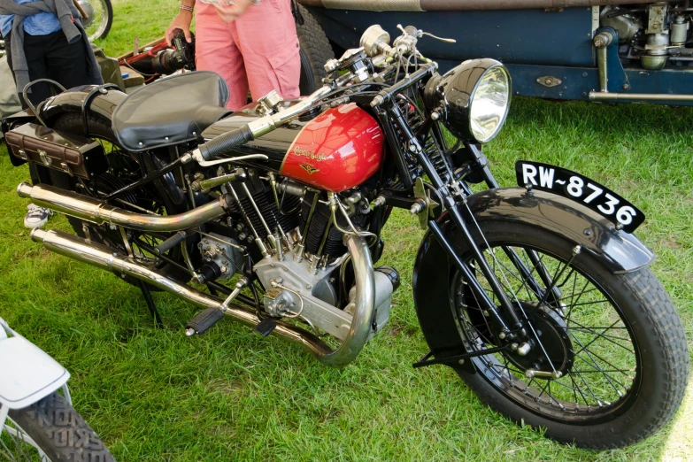 a red motorcycle is sitting on a grassy lawn