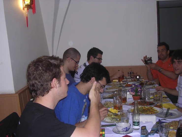 a group of people are sitting at a table eating