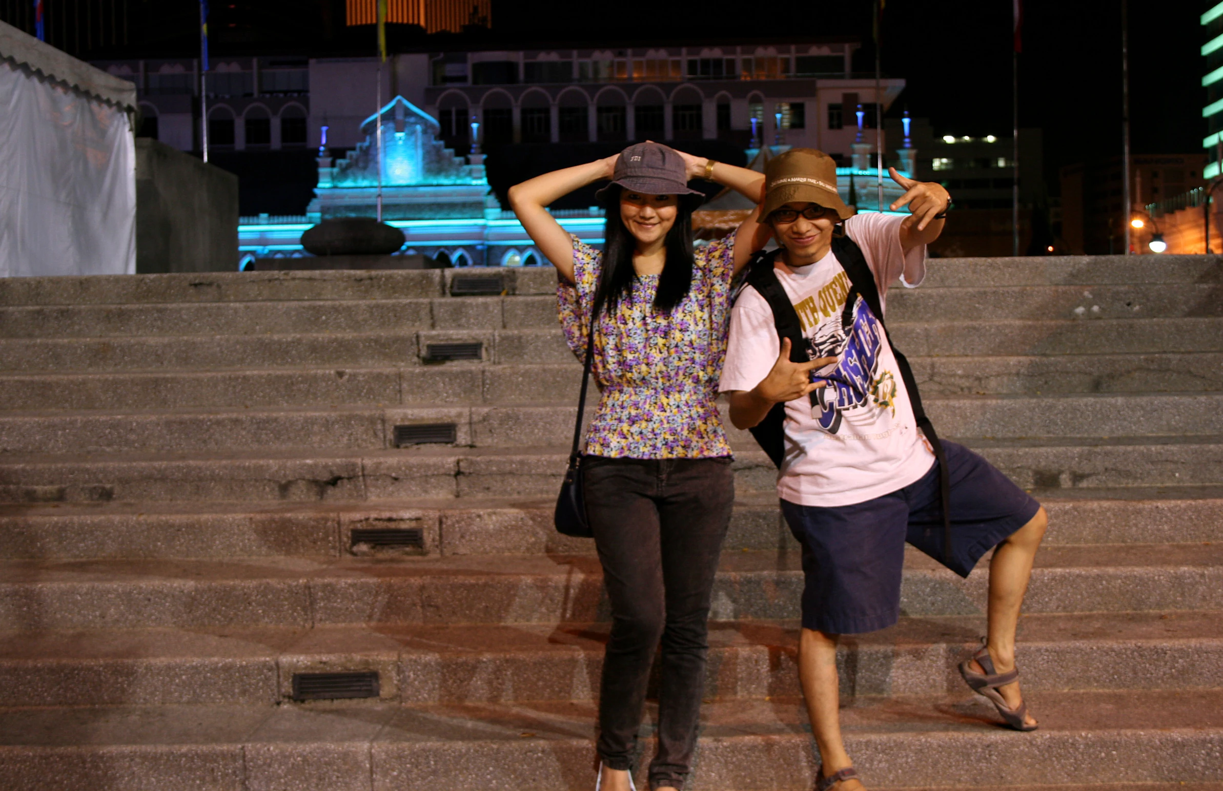 two people posing on stairs in front of a building