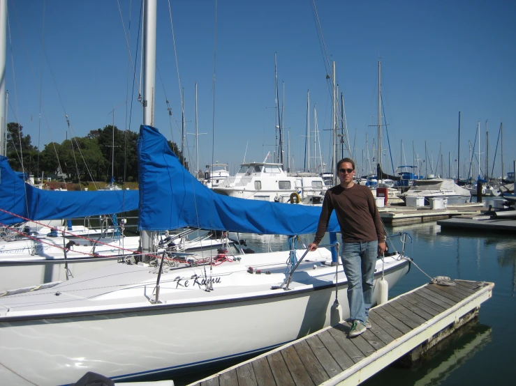 a man on a dock next to some white boats