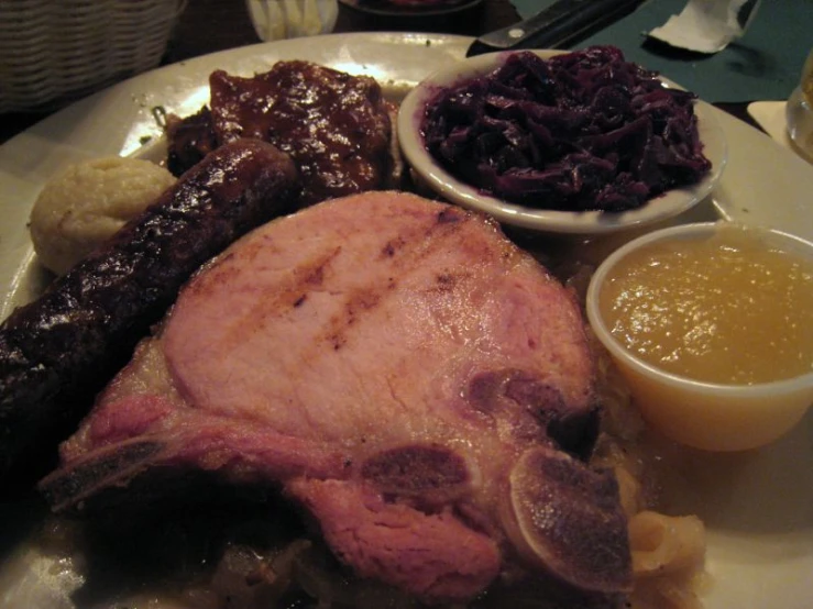 a plate full of food with meat, pasta and other foods