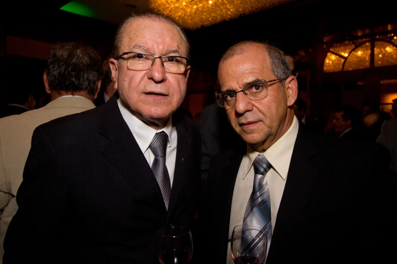 two men posing for the camera in suit and tie