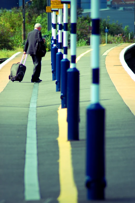 a man walks down the road holding his luggage