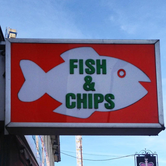 an advertit for fish and chips hangs off the side of a building