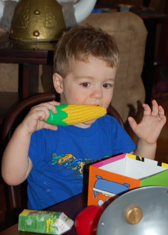 a small child wearing blue shirt with food in mouth