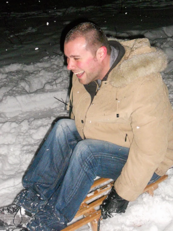 a man riding a sled in the snow