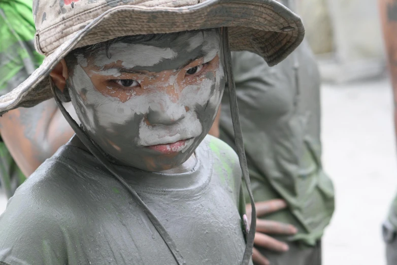 an outdoor po shows a little boy with his face painted in white