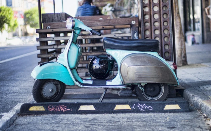 a moped sitting on the curb near a street