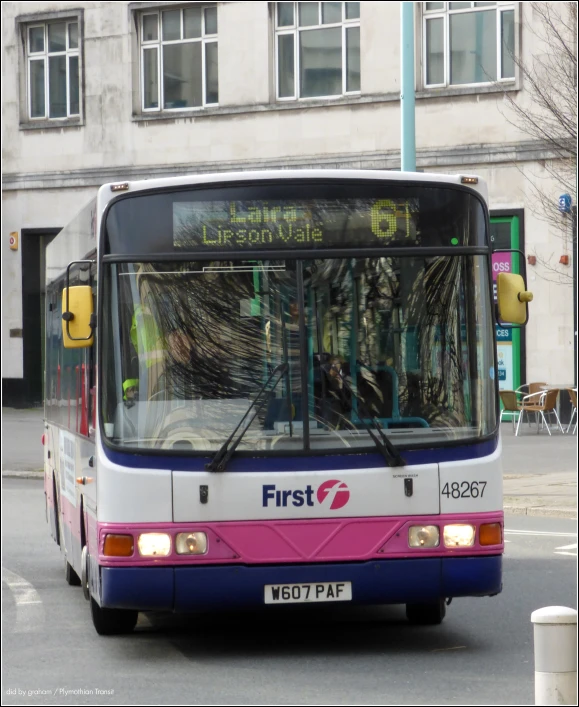 the front of a bus driving past a building