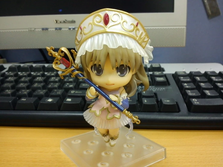 a cute toy with a crown on her head standing on a keyboard