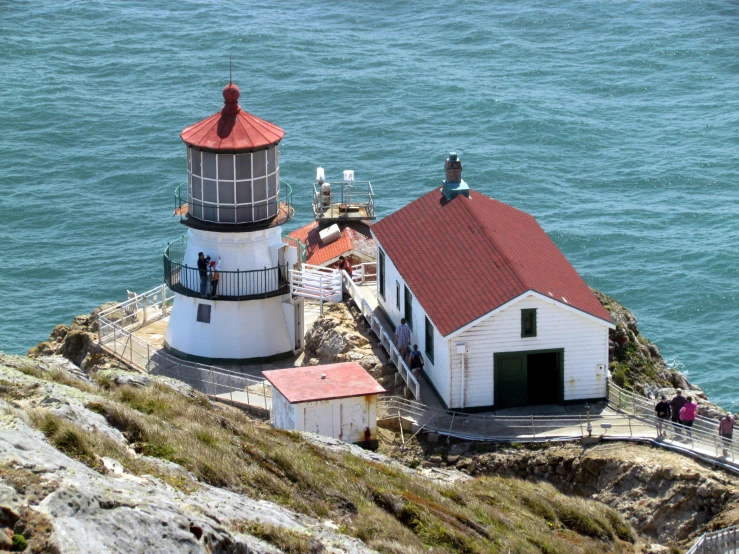 some people on a walk looking at the lighthouse