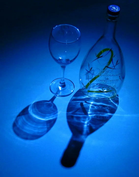 a wine glass, bottle and wineglass are set on a table