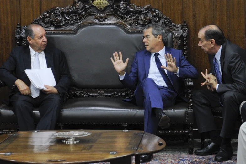 three men in suits and ties sitting down