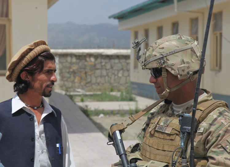 two men in desert colored gear with rifles