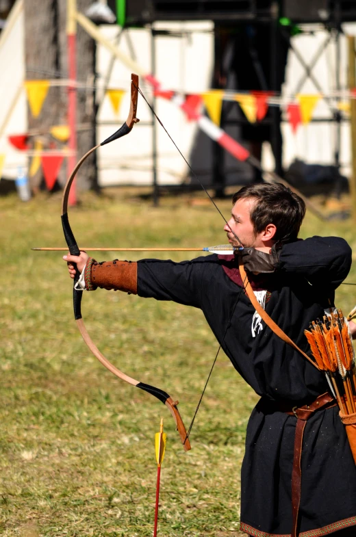 a man dressed in costume aims a bow and arrow