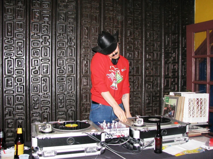 a person in red shirt and headphones on mixing equipment