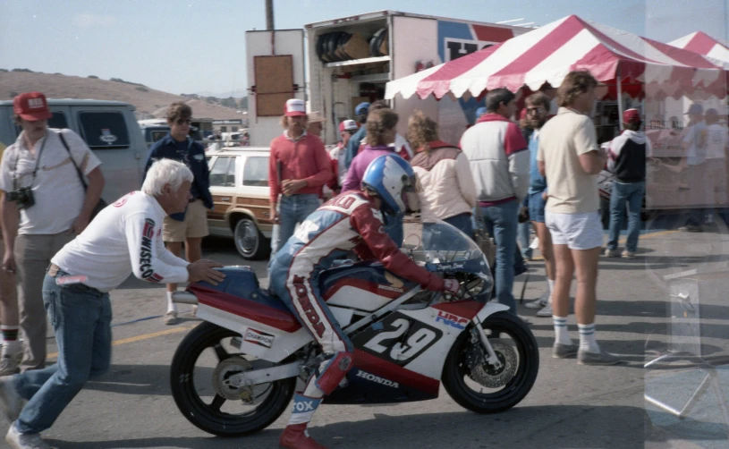 a group of people watching a man on his motorcycle