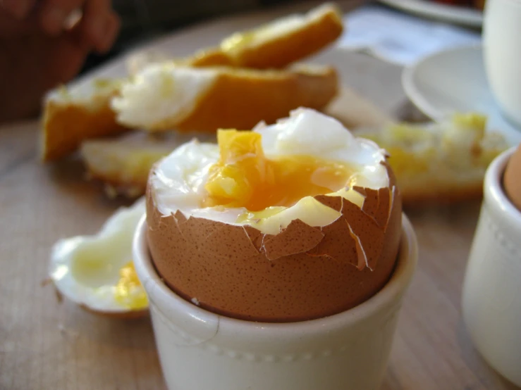 a pastry with icing and a few pieces of bread behind it