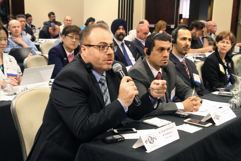 people in business suits at tables during an event