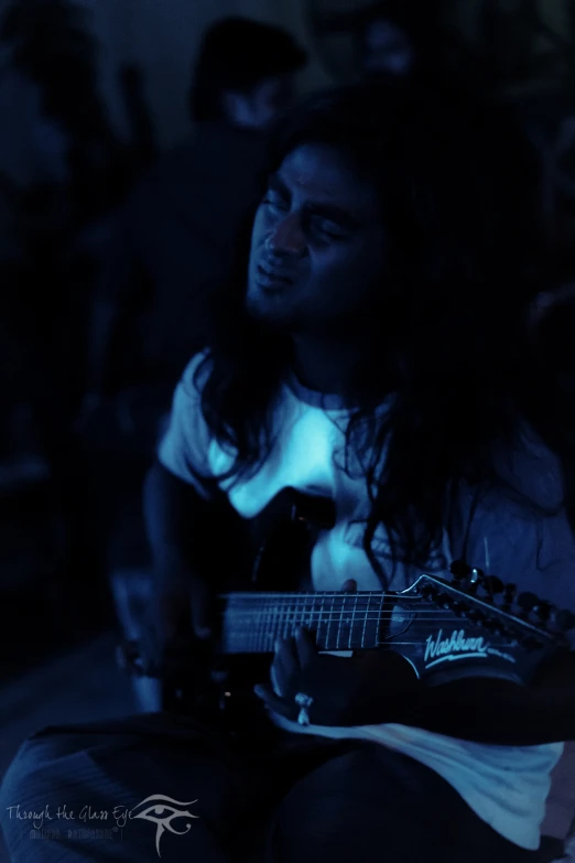 a person that is playing a guitar in a dark room