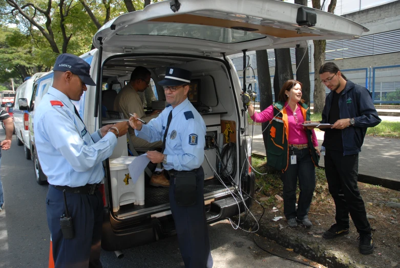 a police officer handing soing to two people