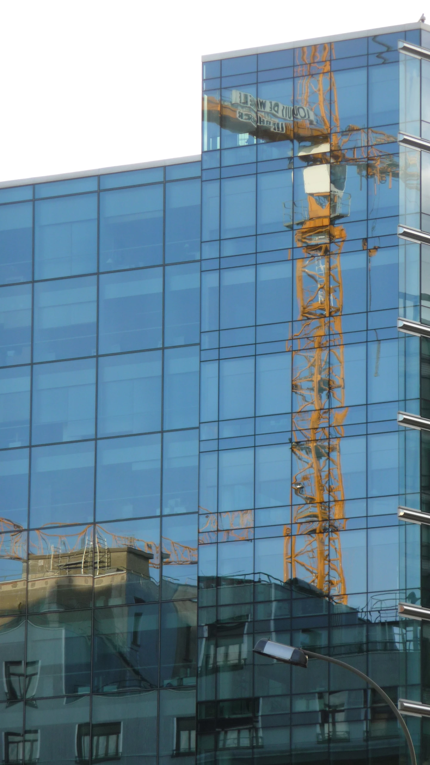 a large building is reflected in the glass windows