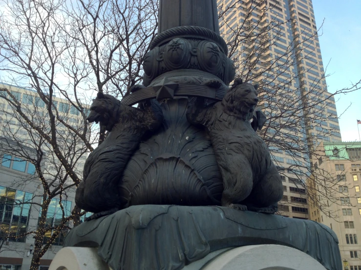 the statue is on a post with a sky scr in the background