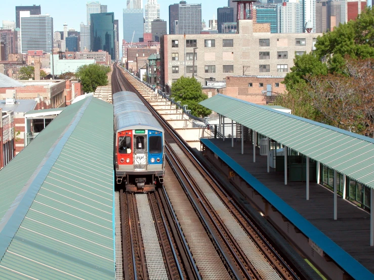 a red and blue train traveling down tracks